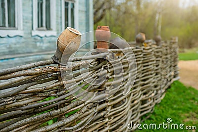 Clay pot on the wicker fence Stock Photo